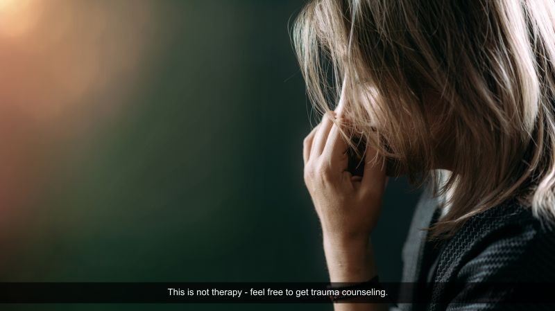A person in distress with their hand to their face, set against a dark background with an overlay encouraging trauma counseling.